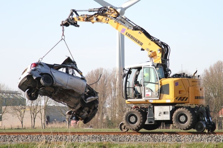 auto aangereden door trein wordt van spoor gehaald
