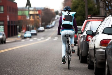 Fietser langs geparkeerde auto's | Getty