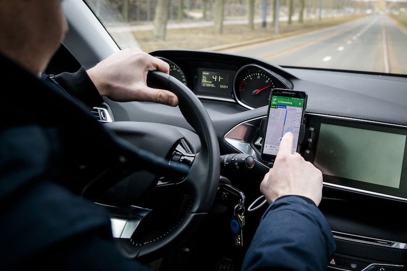 Telefoon achter stuur Google Maps navigatie (ANP)